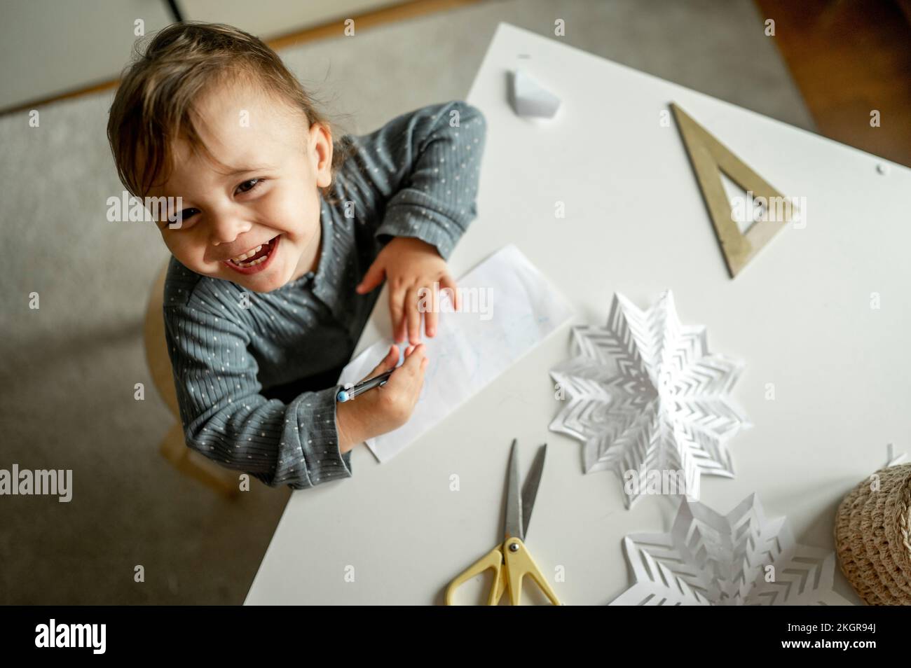 Glücklicher Junge mit Stift und Papier zu Hause zeichnen Stockfoto