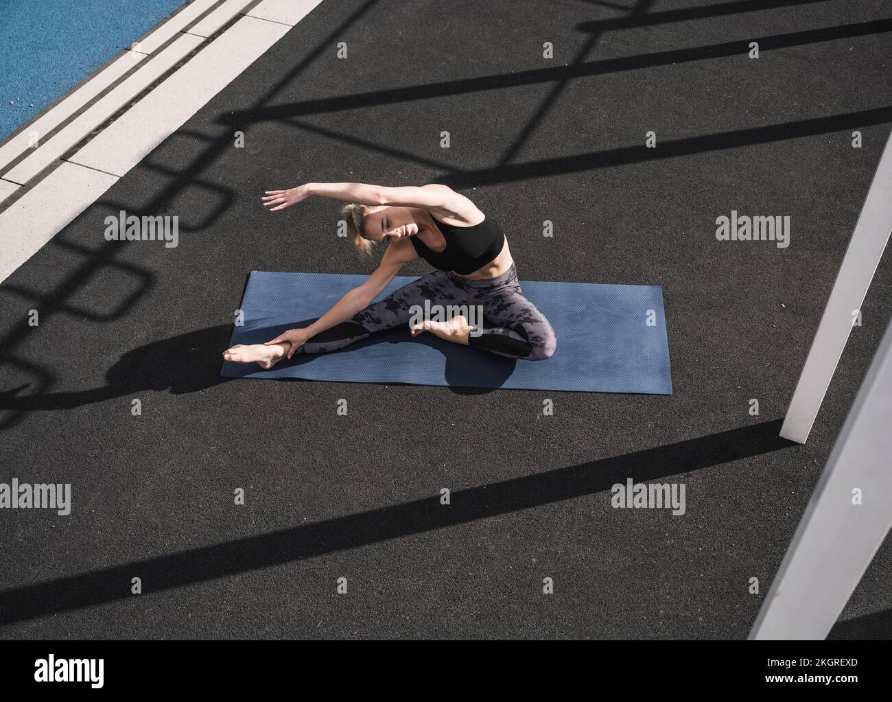 Sportlerin, die auf Yoga-Matte Stretching-Übungen macht Stockfoto
