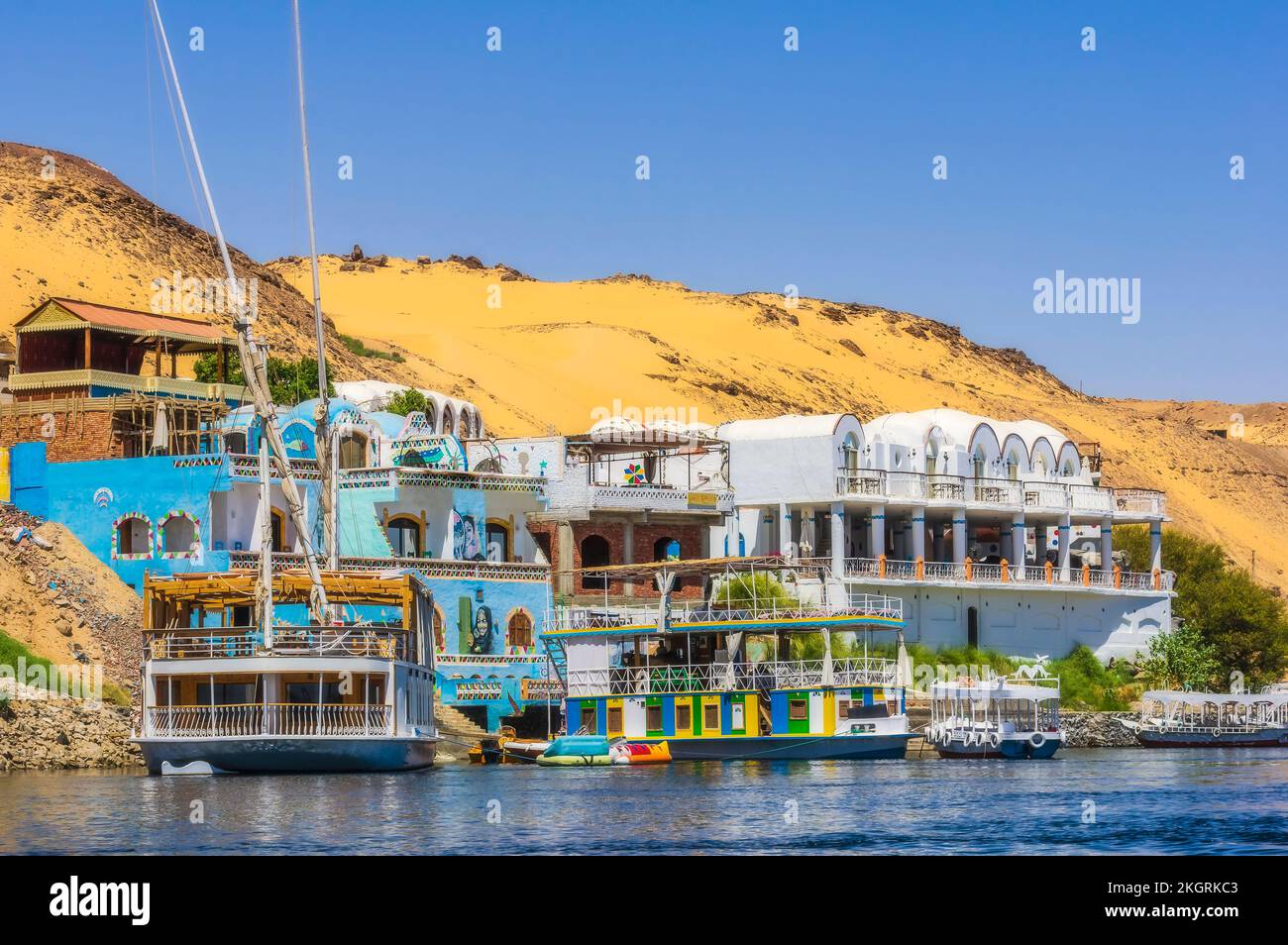 Ägypten, Assuan-Gouvernement, Assuan, Tourboote vor Gebäuden am Flussufer im Sommer Stockfoto