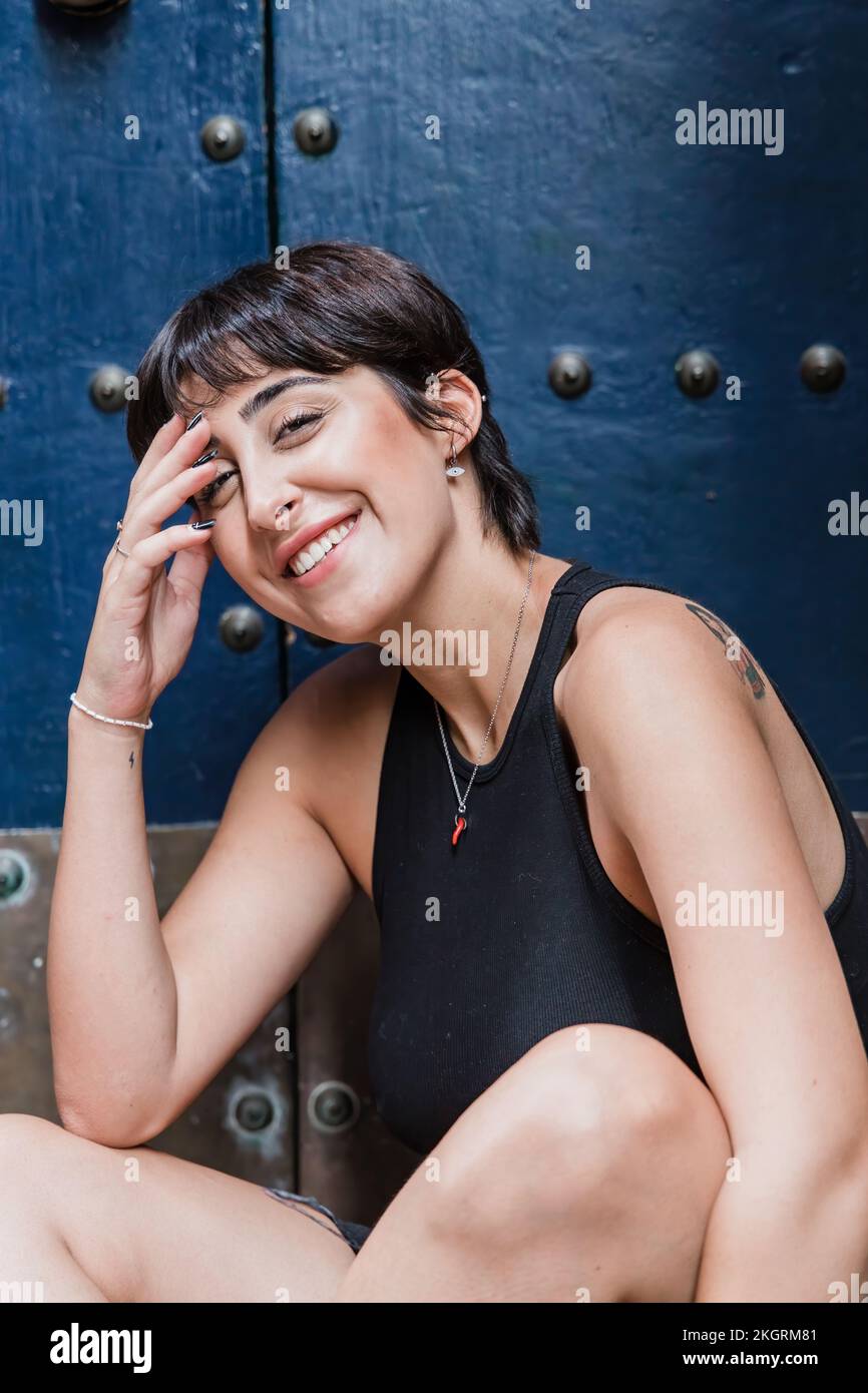 Glückliche Frau mit kurzen Haaren vor der Tür Stockfoto