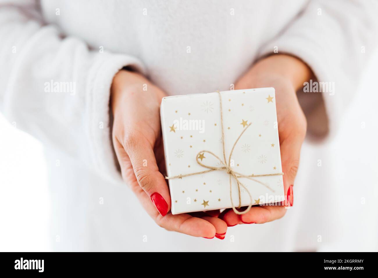 Hände einer Frau, die ein Weihnachtsgeschenk hält Stockfoto