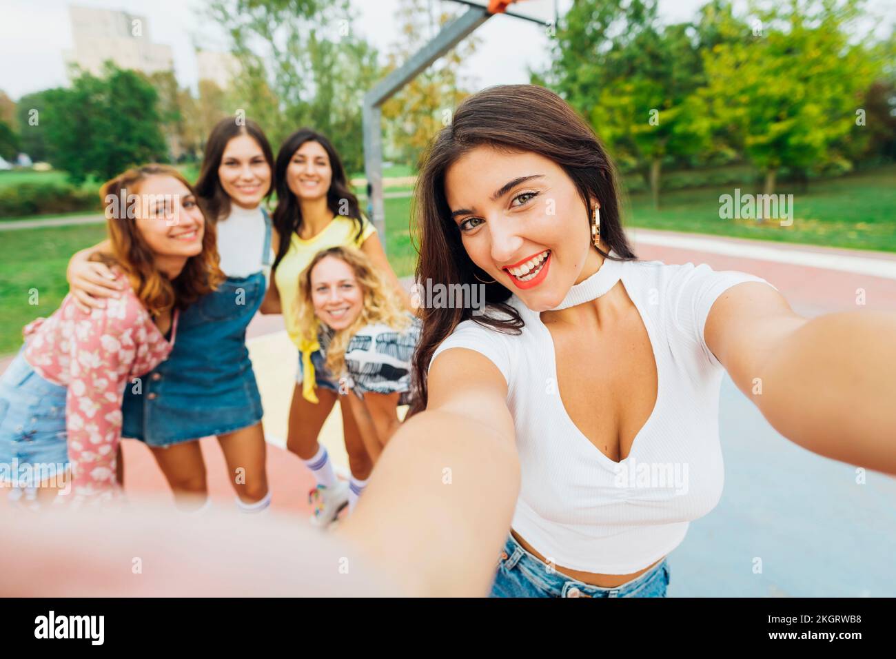 Glückliche Frau macht Selfie mit Freunden auf dem Sportplatz Stockfoto