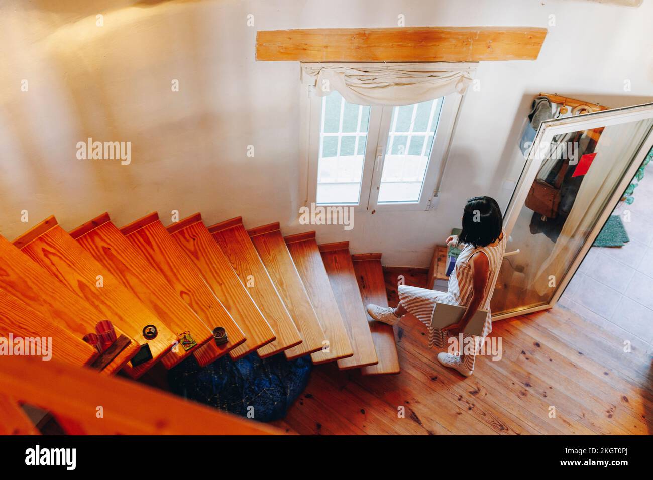 Frau mit Laptop, die auf der Treppe hochkommt Stockfoto