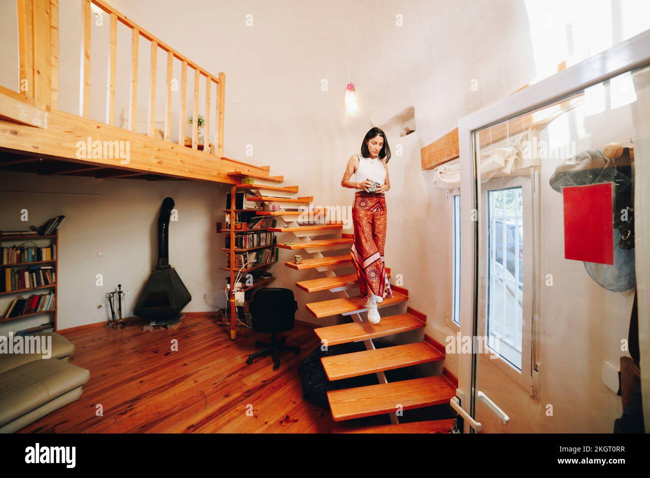 Reife Frau, die zu Hause die Treppe runterzieht Stockfoto