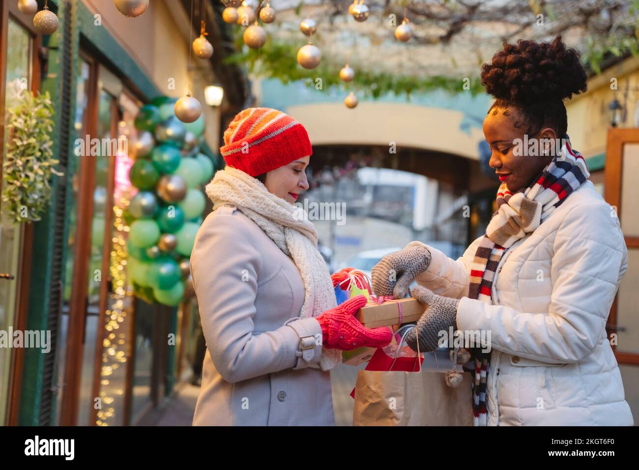 Eine Frau in warmer Kleidung, die einem Freund ein Weihnachtsfest schenkt Stockfoto
