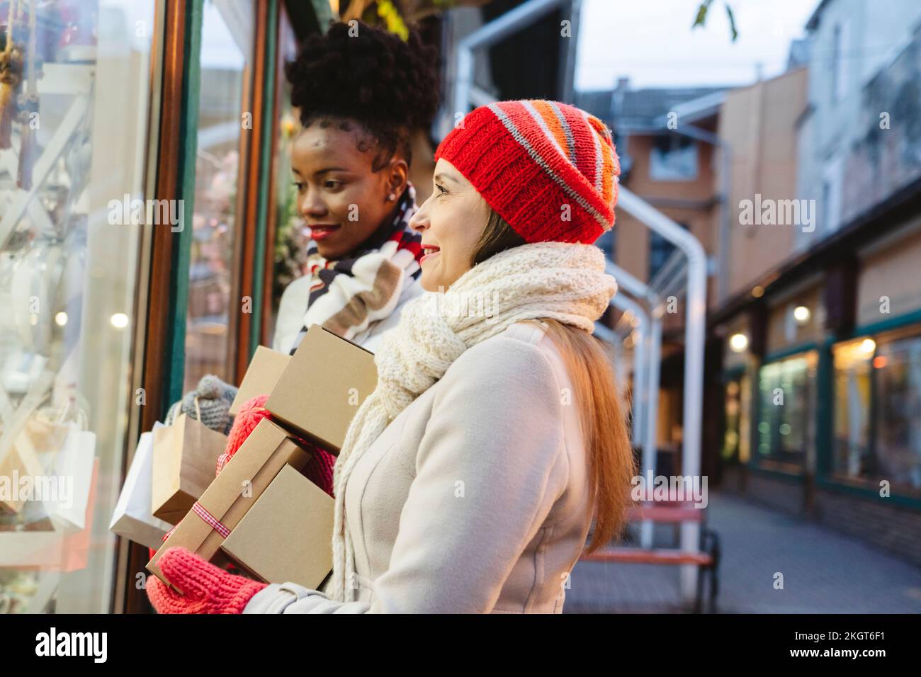 Frauen mit Geschenken, die beim Weihnachtsfest Schaufensterbummel machen Stockfoto