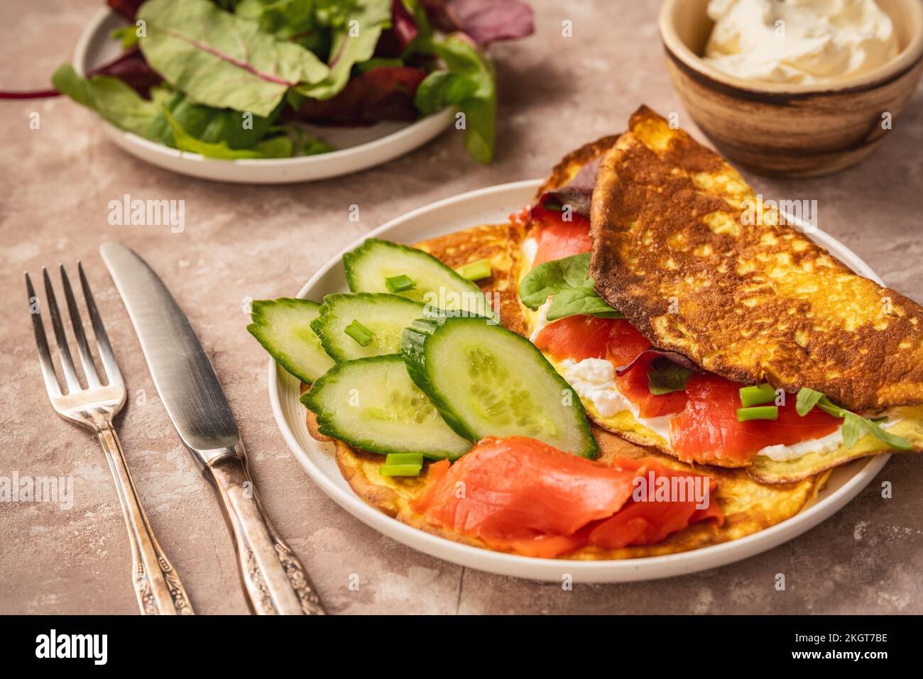 Keto Lunch: Keto-Pfannkuchen mit Ricotta und geräuchertem Lachs auf rustikalem Hintergrund. Stockfoto