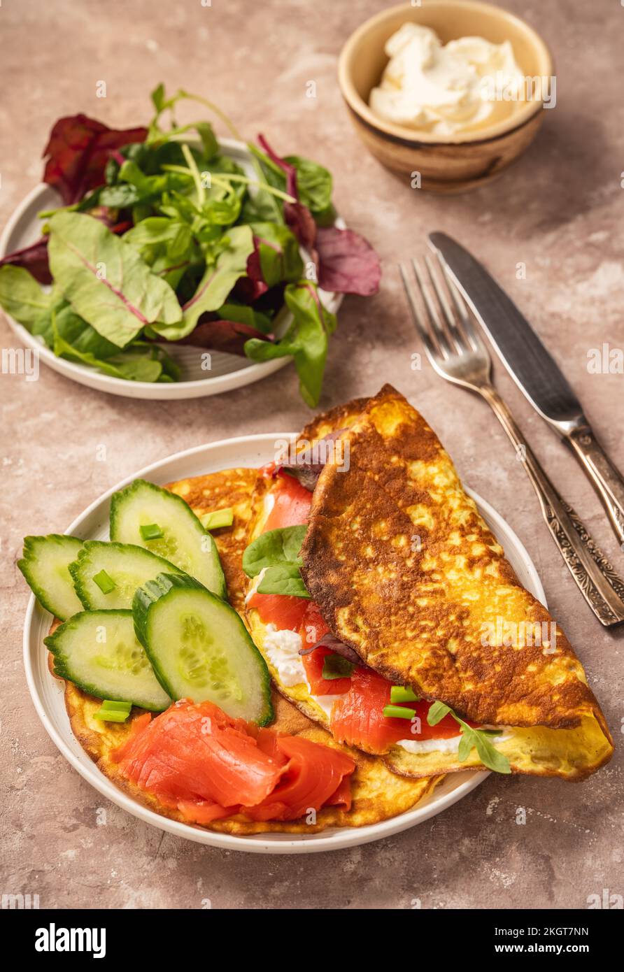 Keto Lunch: Keto-Pfannkuchen mit Ricotta und geräuchertem Lachs auf rustikalem Hintergrund. Stockfoto