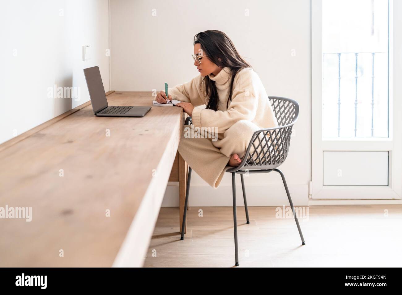 Junger Freiberufler mit Laptop, der im Home Office arbeitet Stockfoto