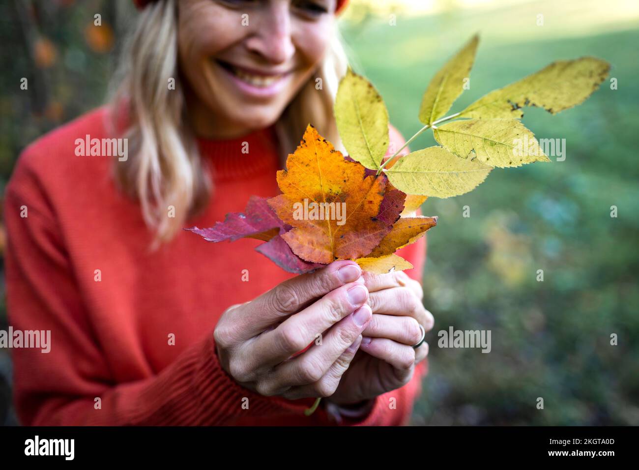 Reife Frau mit Herbstblättern Stockfoto