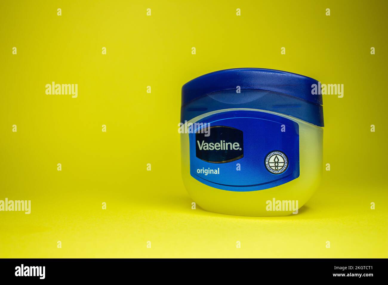 Vaseline-Flasche auf gelbem Hintergrund. Hautpflegemittel Vaseline oder Vaseline. Afjonkarahisar, Türkei - 19. November 2022. Stockfoto