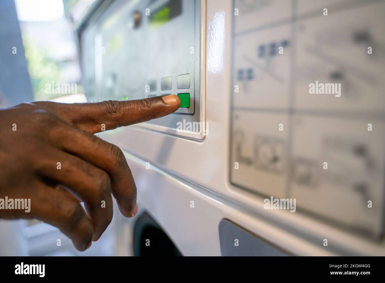 Person, die die Einstellungen an einer Waschmaschine auswählt Stockfoto