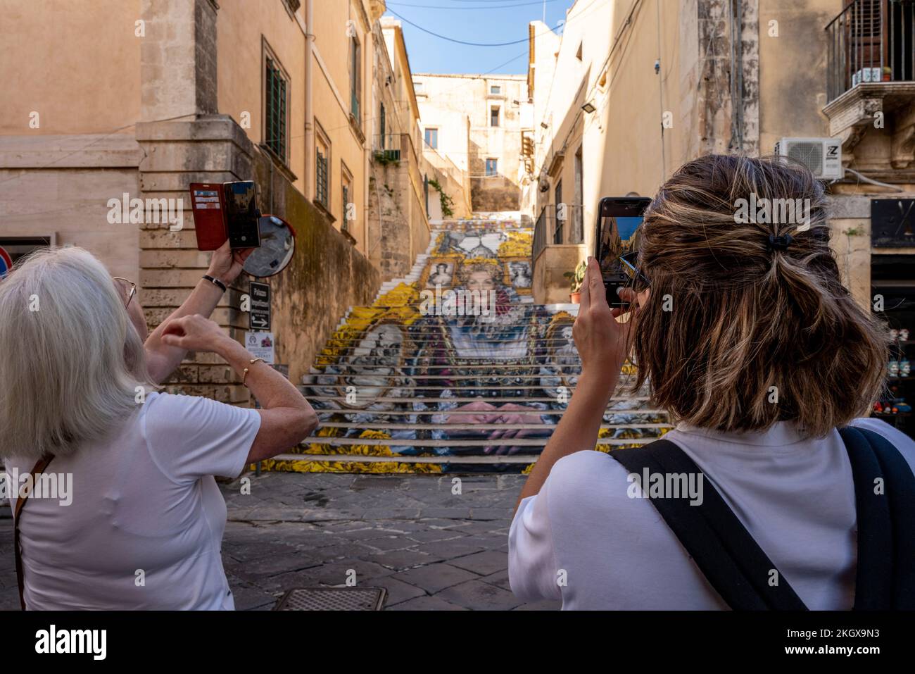 Touristen fotografieren die farbenfrohen Stufen in der Altstadt von Noto, Sizilien, Italien. Stockfoto