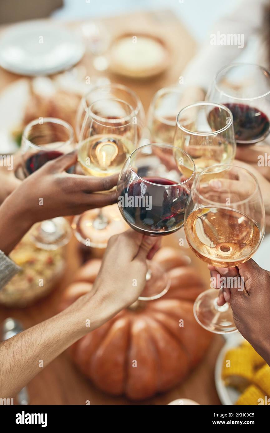 Wein, Anfeuerungen und Gläser zum anstoßen an weihnachten, Feiertagsfeier mit Essen, Freunden und Familie zusammen. Hände, Weingläser und Freundschaft, feiern Stockfoto