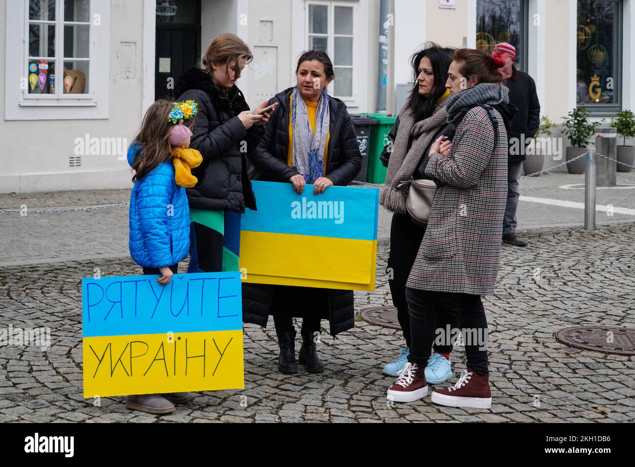 Eine Mutter mit ihren beiden Kindern wartet auf den Beginn einer Demonstration gegen den russischen Krieg in der Ukraine. Sie haben Schilder in ukrainischen Farben. Stockfoto