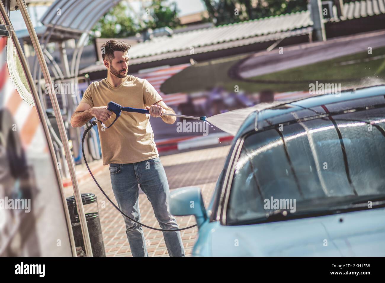 Erfahrener Autoverteiler wäscht ein Kundenfahrzeug im Freien Stockfoto