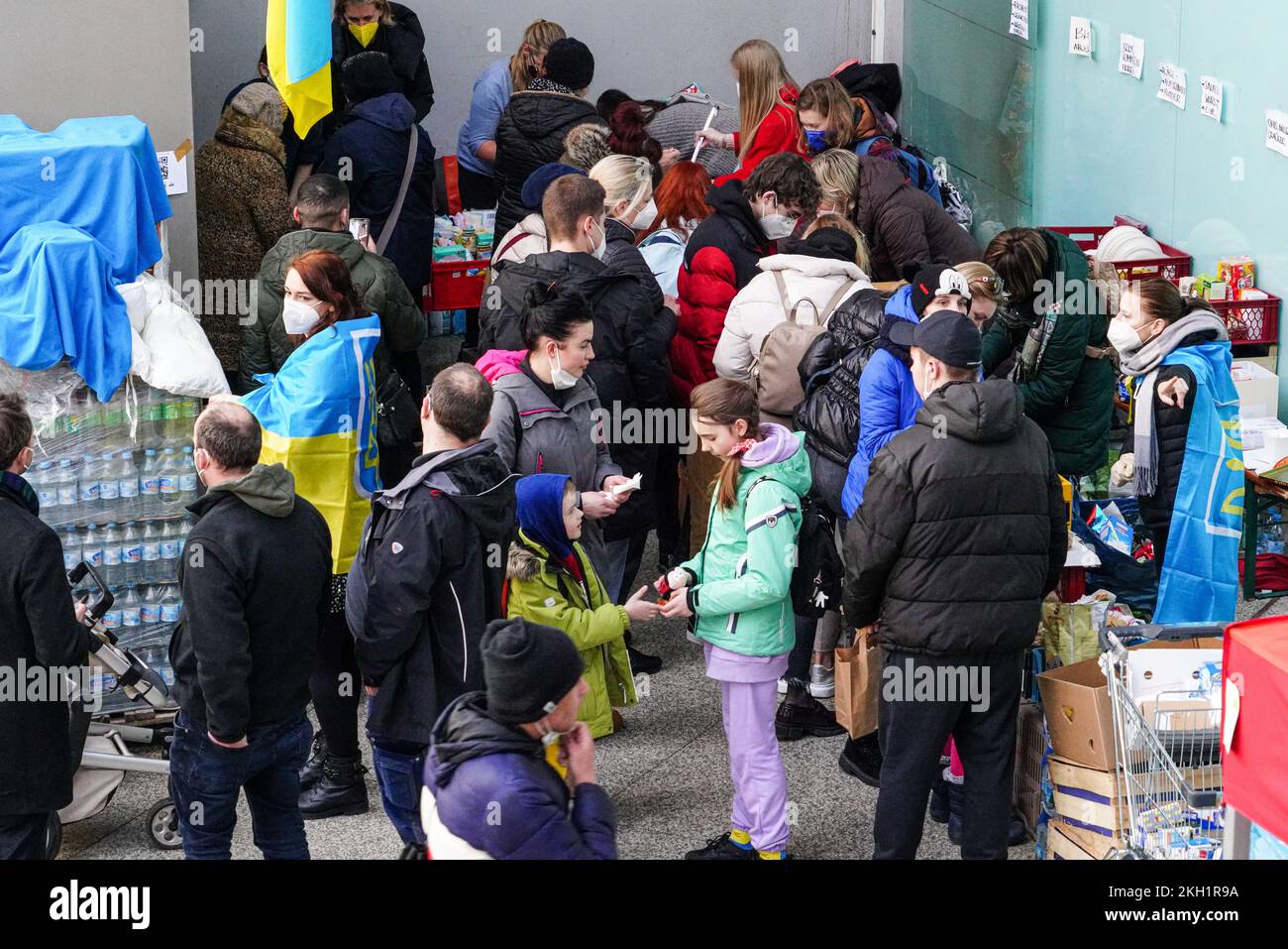 Zahlreiche Menschen aus der Ukraine stehen am Caritas Imbissstand am Münchner Hauptbahnhof. Stockfoto