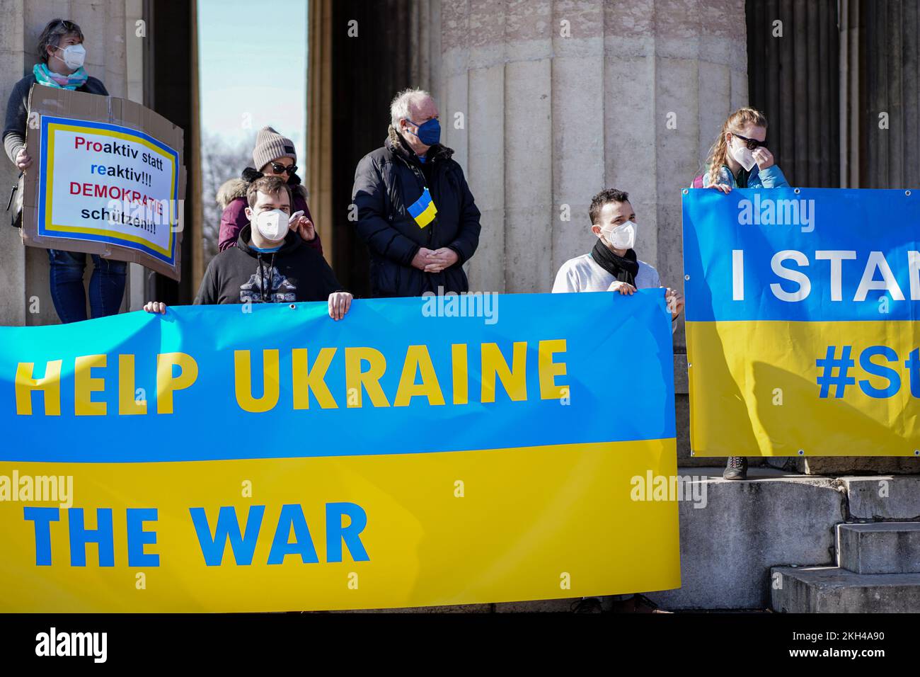 Die Menschen halten während einer Demonstration gegen den Russischen Krieg in der Ukraine große Banner in den ukrainischen Nationalfarben mit Inschriften Help Ukraine. Stockfoto