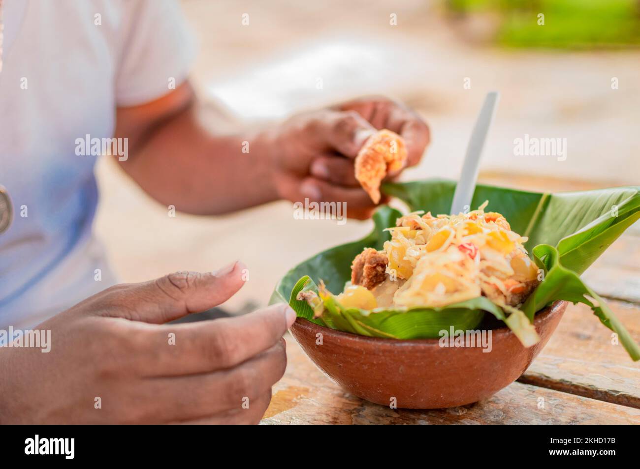 Nahaufnahme einer Person, die Vigoron auf dem Tisch isst. Einheimische Person, die ein traditionelles vigorón isst. Das Vigoron typische Essen von Granada, Konzept der typischen Speisen von Stockfoto