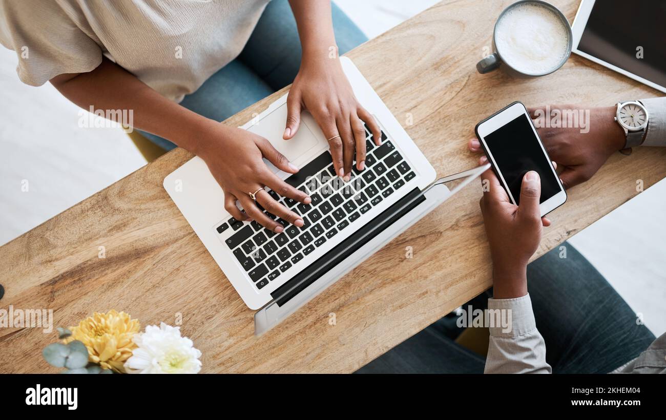 Hände, Laptop und Telefon mit einem Business-Team im Café, das von oben zusammenarbeitet. Zusammenarbeit, Technologie und Remote-Zusammenarbeit mit einem Schwarzen und Stockfoto