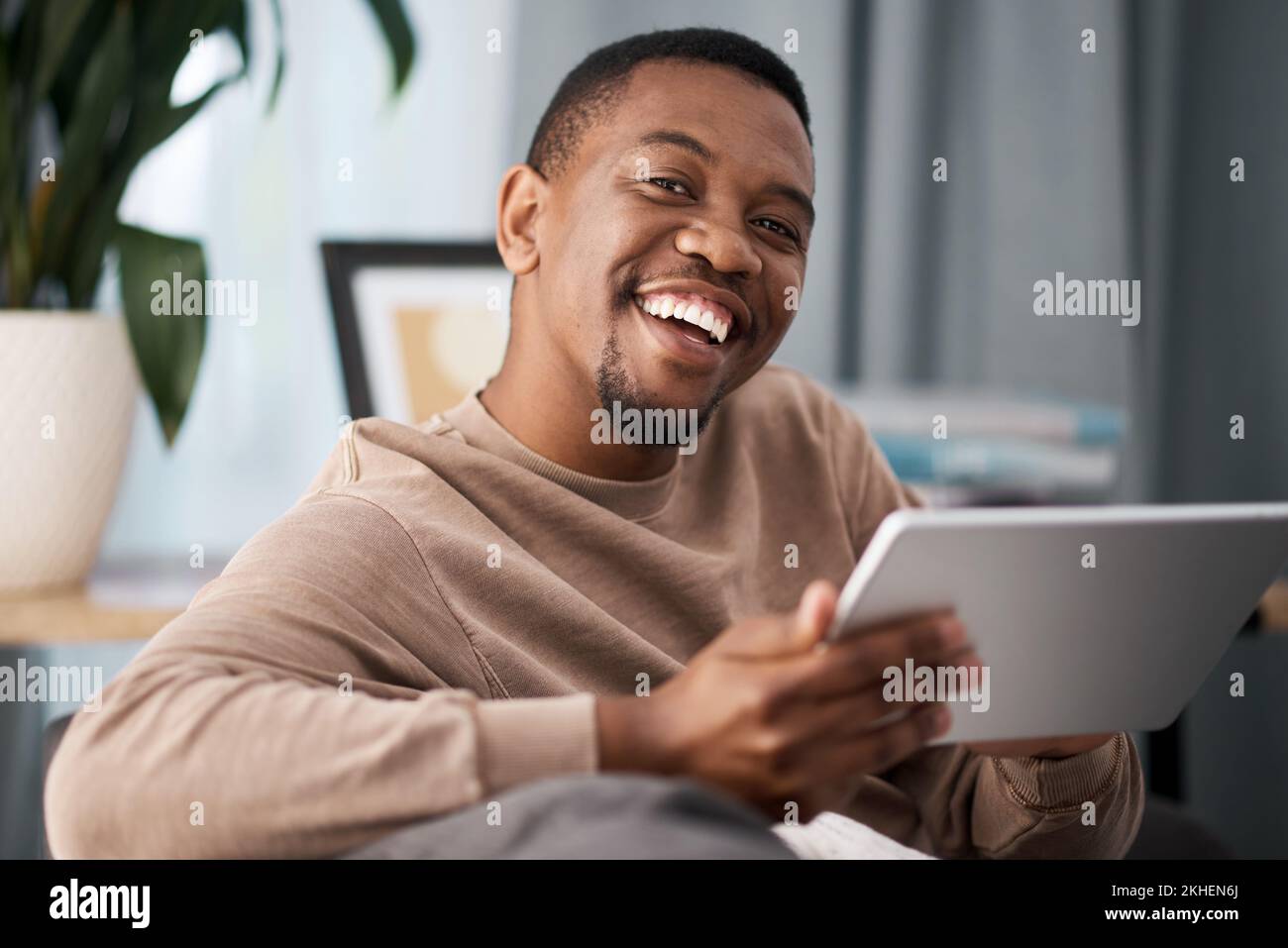 Black man, Tablet und Portrait Smile für Unterhaltung, Filmstreaming oder schnelle Verbindung zu Hause. Ein glücklicher afroamerikanischer Mann, der lächelt Stockfoto