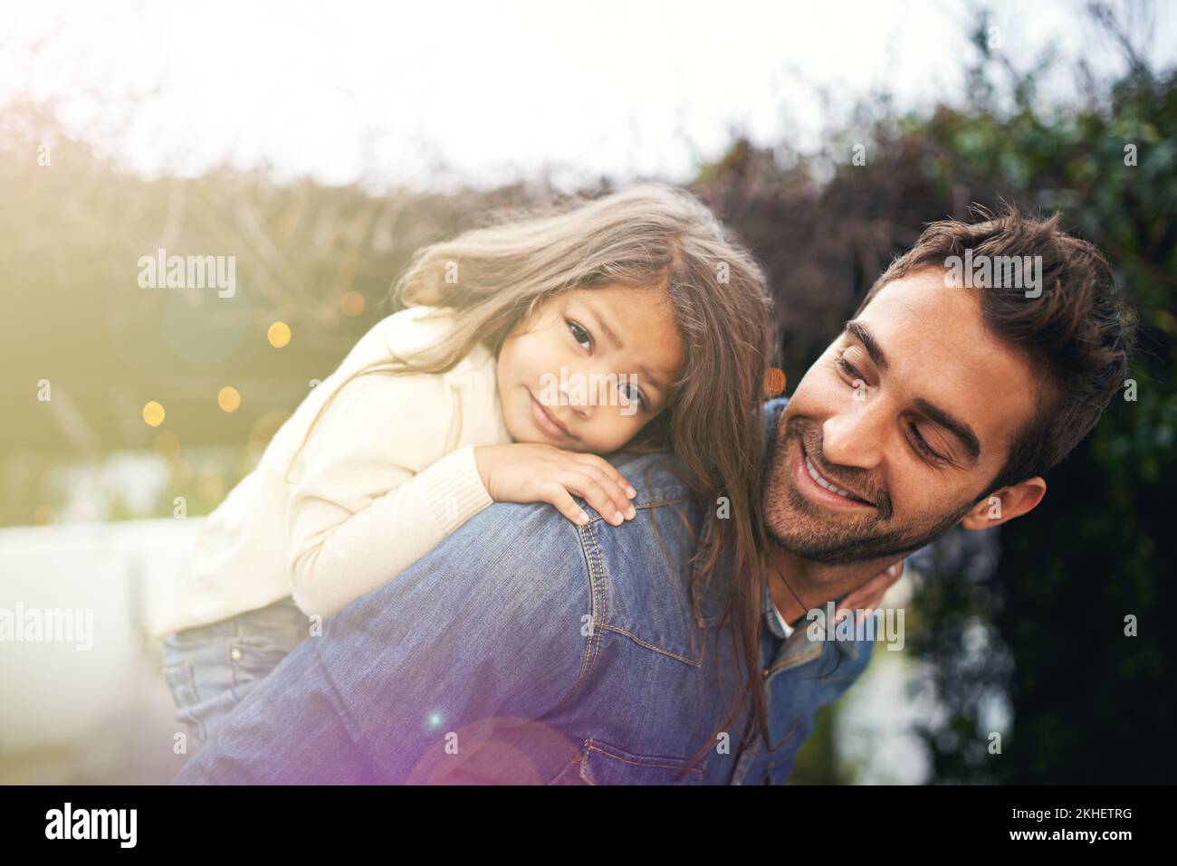 Daddy-Hingabe. Ein kleines Mädchen und ihr Vater, die draußen zusammen spielen. Stockfoto