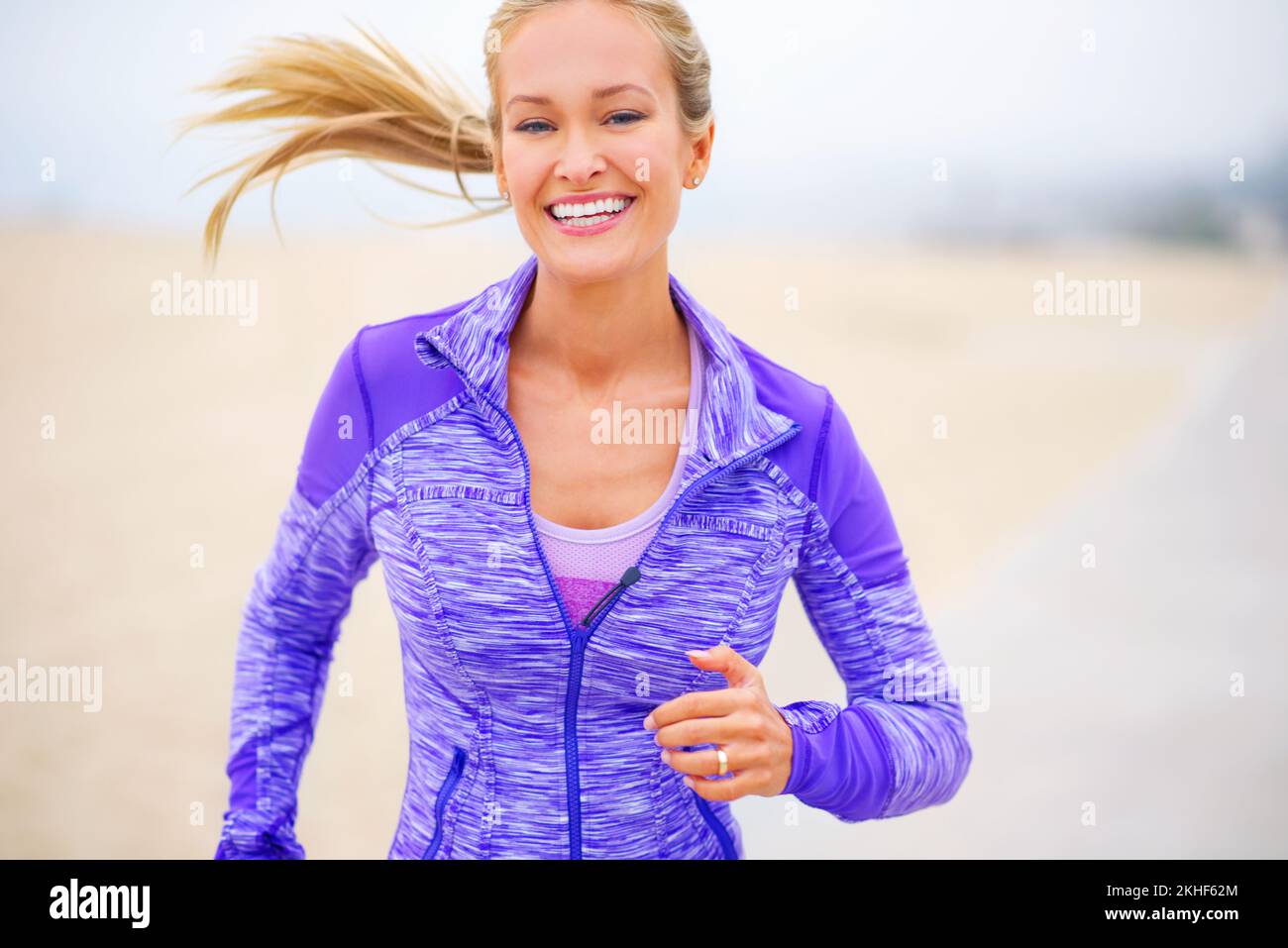 Sie lässt es einfach aussehen, fit zu werden. Porträt einer jungen Frau, die in Strandnähe joggt. Stockfoto