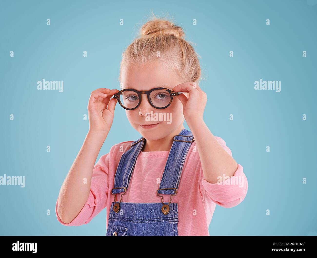 Sie sehen intelligent aus und fühlen sich scharf. Studioaufnahme eines kleinen Mädchens mit Hipster-Brille auf blauem Hintergrund. Stockfoto