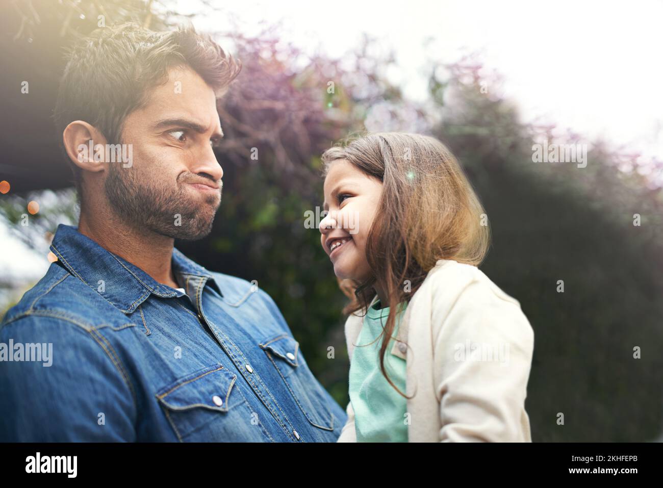 Mit seinem kleinen Mädchen herumalbern. Ein kleines Mädchen und ihr Vater, die draußen zusammen spielen. Stockfoto