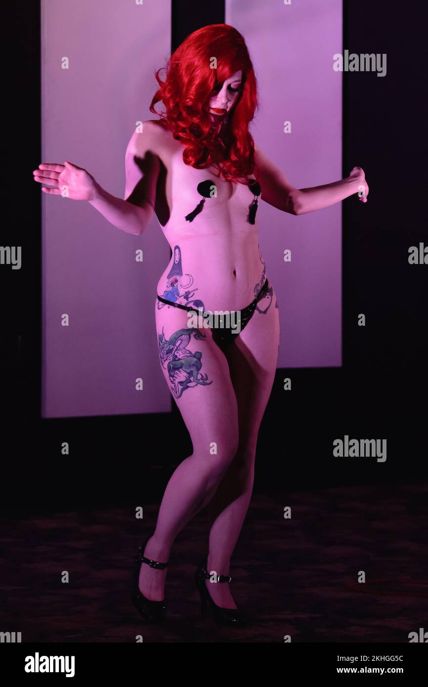 Eine Frau mit roter Perücke tanzt in einer Burlesque-Show Stockfoto