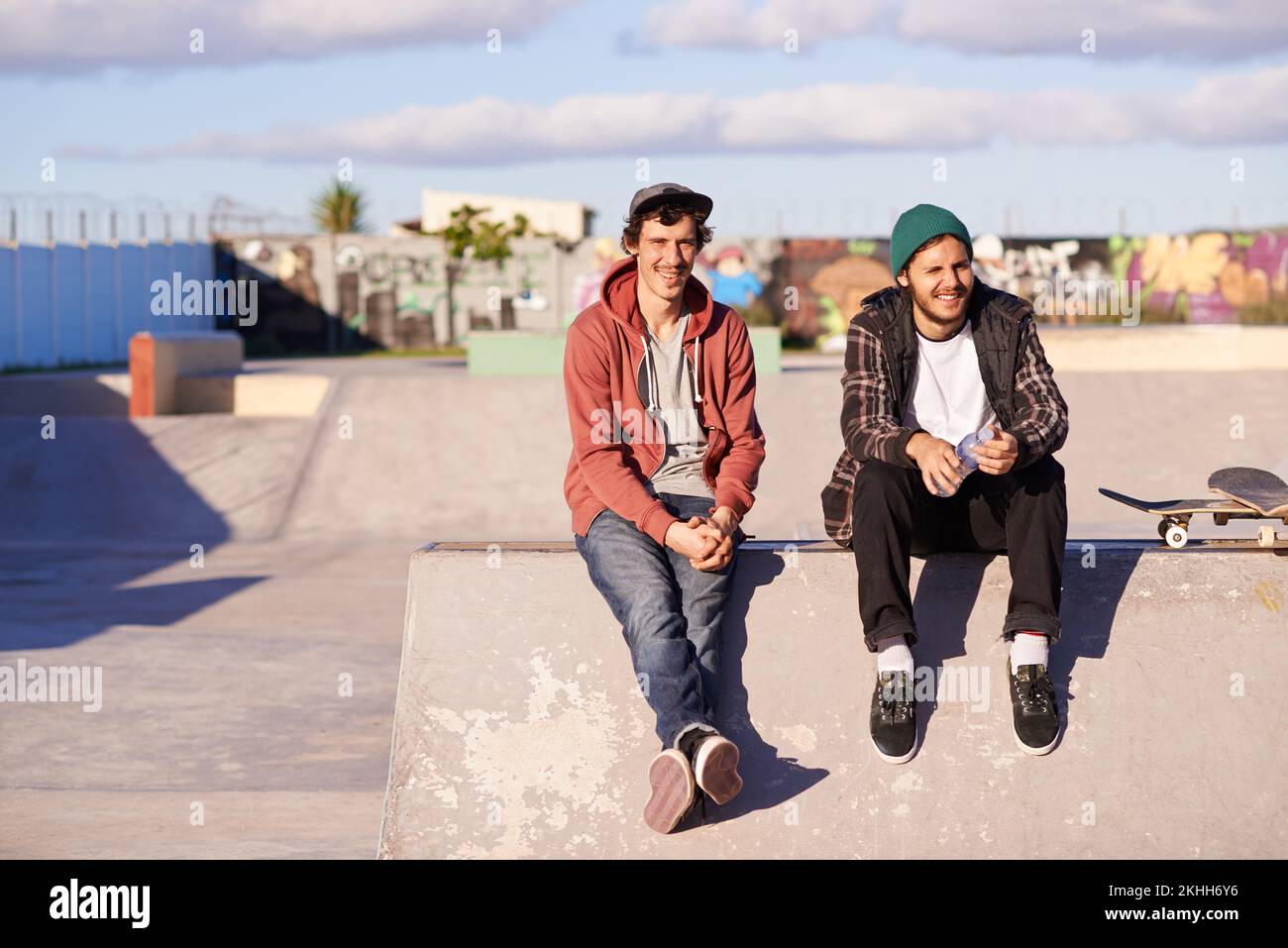 Ihr Lieblingsort zum Abhängen. Zwei Schlittschuhläufer sitzen zusammen im Skatepark. Stockfoto