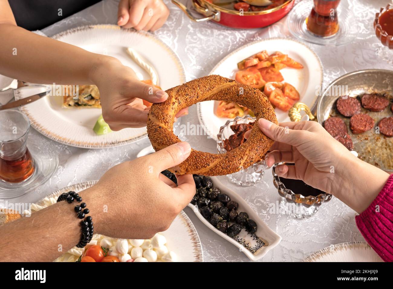 Türkischer Bagel heißt Simit. Freunde teilen sich ein traditionelles Frühstück zu Hause. Der Sitztisch beginnt den Tag mit einem leckeren Gourmet-Brunch. Stockfoto