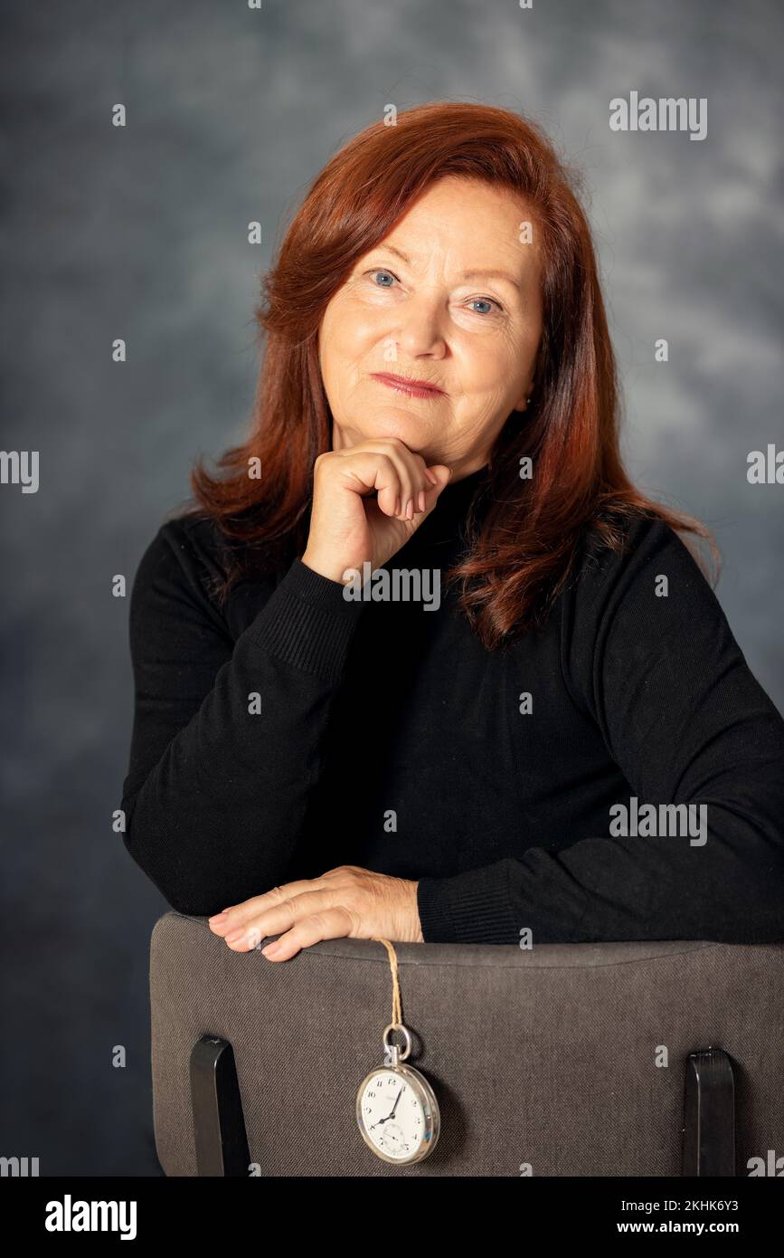 Porträt einer stilvollen 60s-jährigen Frau auf grauem Hintergrund. Selbstbewusste, stilvolle europäische reife Frau mittleren Alters Stockfoto