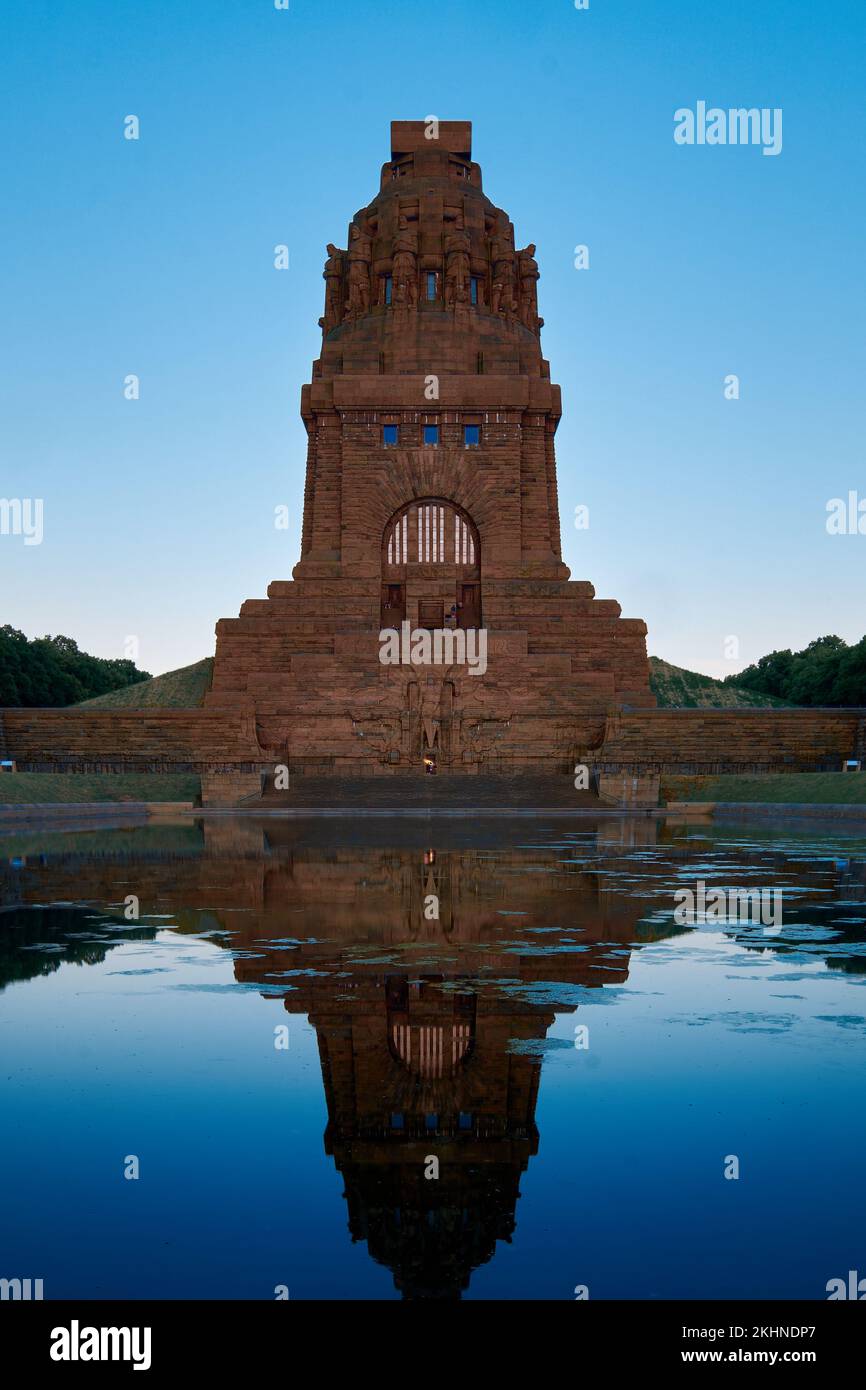 Ein vertikales Bild des Denkmals für die Schlacht der Nationen mit seiner Reflexion über Wasser in Leipzig Stockfoto