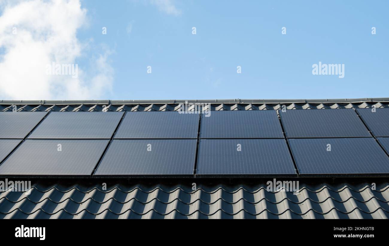 Neues ecologic Haus mit Sonnenkollektoren Alternative zu konventioneller Energie. Die Batterie wird von einer Solarzelle geladen Werbung Grüne Energie Nachhaltiges Leben Erneuerbare alternative Energie Stockfoto