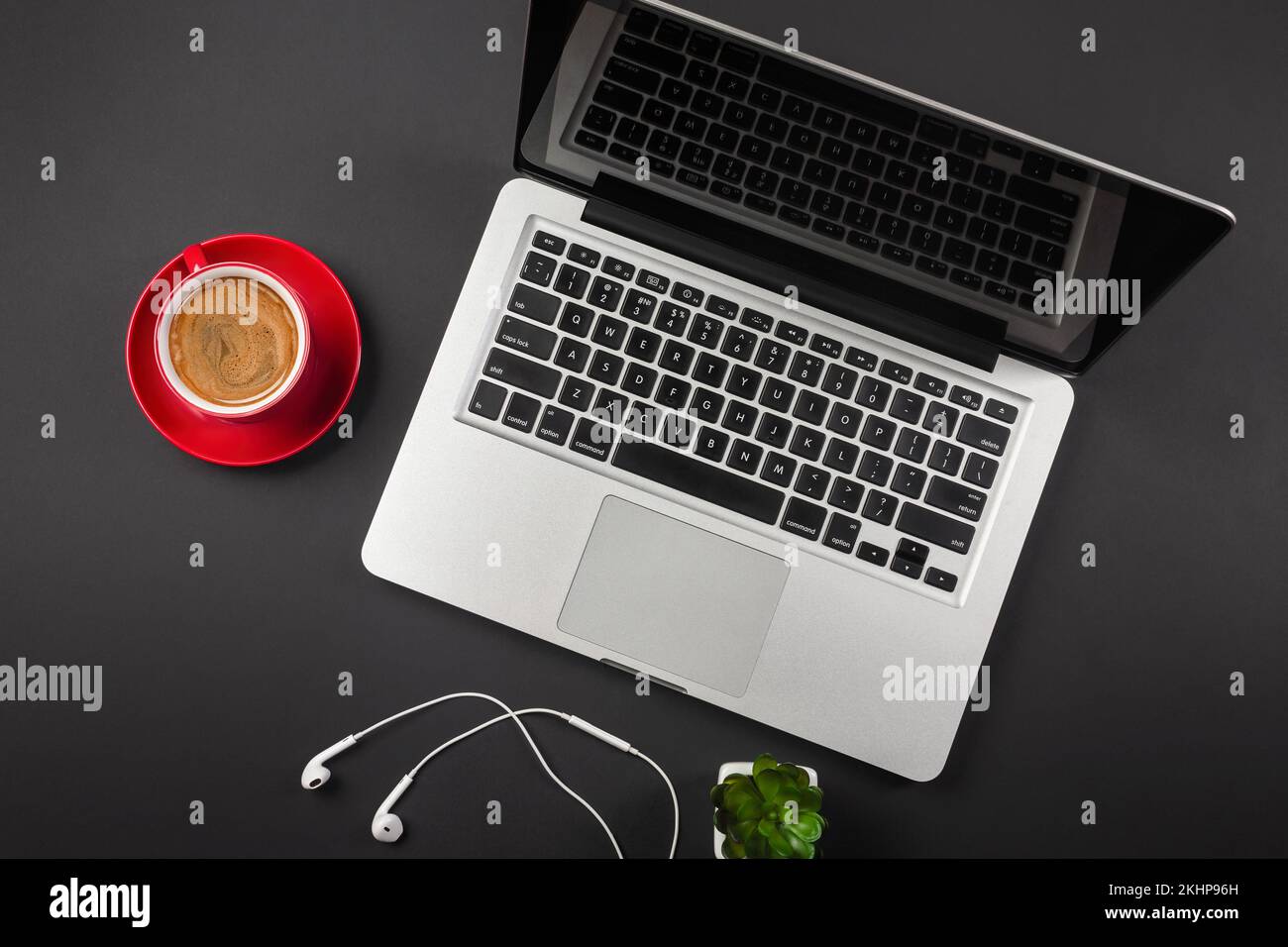 Ein Notebook auf einem schwarzen Desktop mit einer Tasse Kaffee, einem Telefon und einem wi-Fi-Schild, arbeiten Sie in sozialen Netzwerken. Draufsicht. Hochwertiges Foto Stockfoto