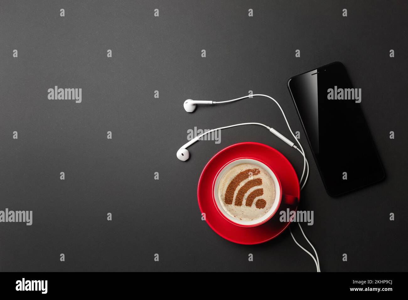 Ein Notebook auf einem schwarzen Desktop mit einer Tasse Kaffee, einem Telefon und einem wi-Fi-Schild, arbeiten Sie in sozialen Netzwerken. Draufsicht. Hochwertiges Foto Stockfoto
