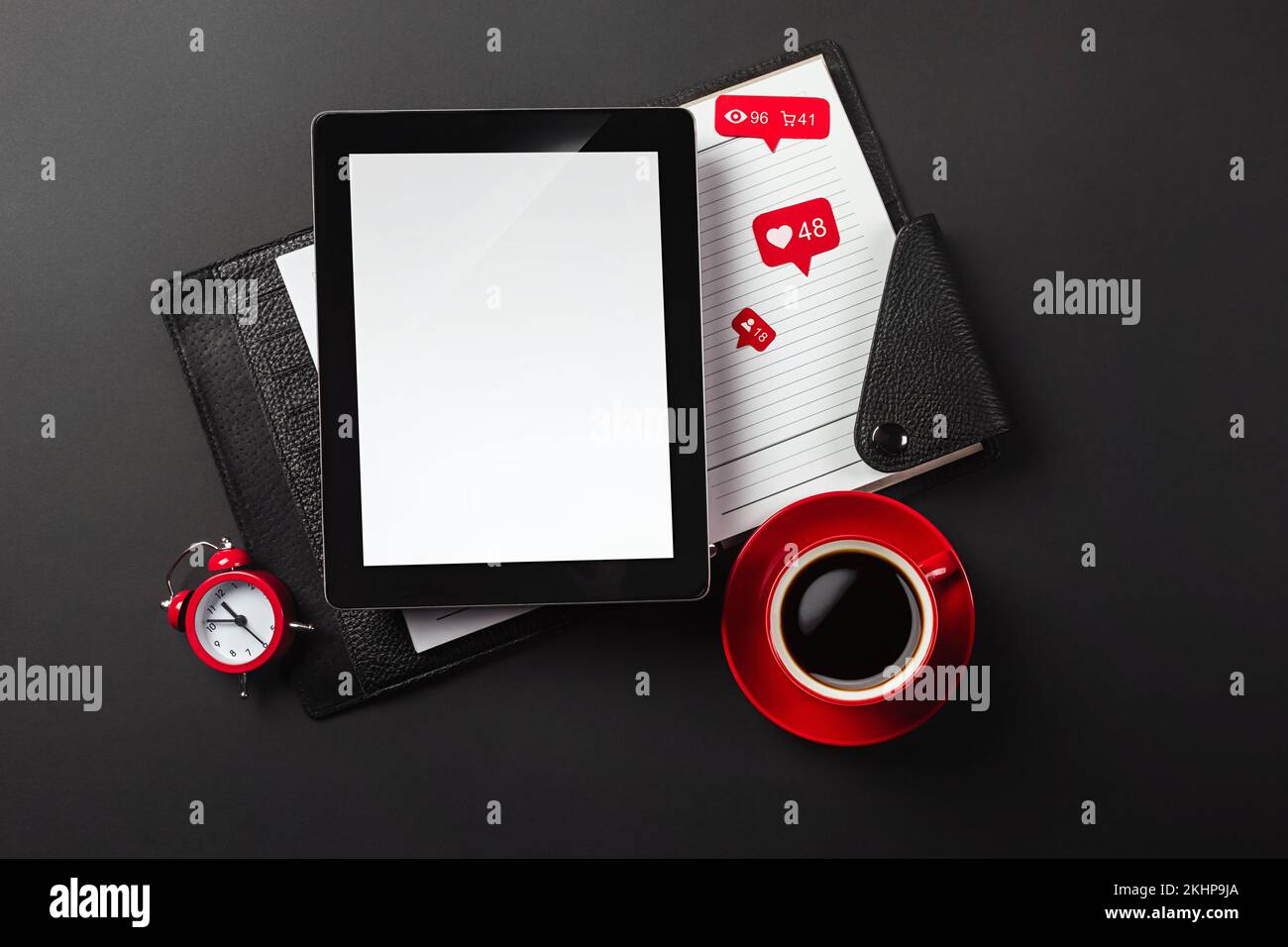 Ein Notebook auf einem schwarzen Desktop mit einer Tasse Kaffee, einem Telefon und einem wi-Fi-Schild, arbeiten Sie in sozialen Netzwerken. Draufsicht. Hochwertiges Foto Stockfoto