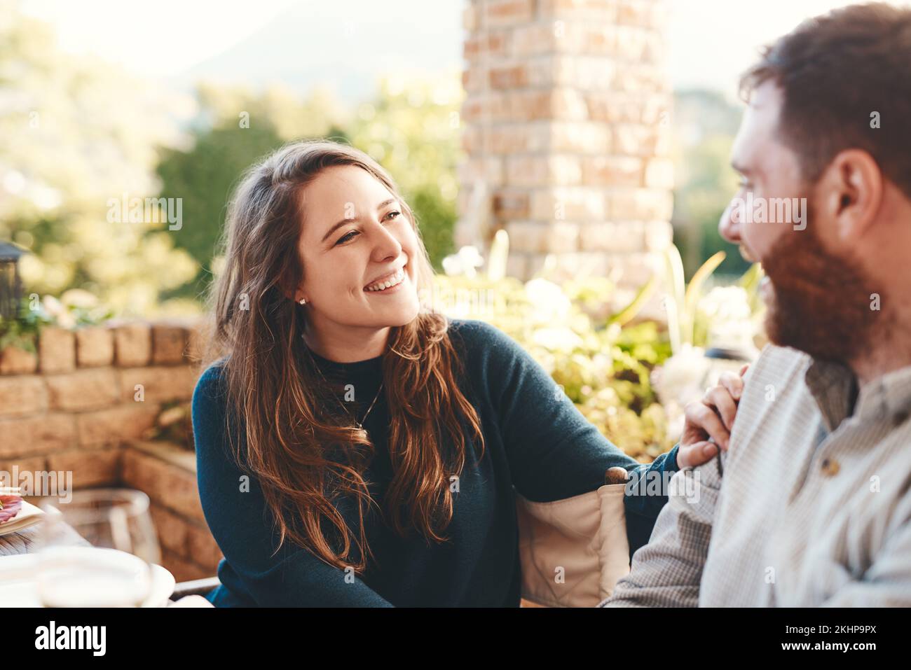 Glückliches Paar, unterhielt sich und draußen auf der Terrasse für eine lustige Unterhaltung während des Frühstücks oder Mittagessens im Sommer. Frau und Mann zusammen für das Glück Stockfoto