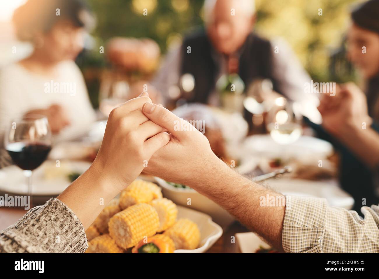 Menschen, die für Essen beten und Essen, um sich zu verbinden, Zeit für Mittagessen und draußen. Religiöse Geste, Gruppe und Händchenhalten für Brunch, Familie Stockfoto