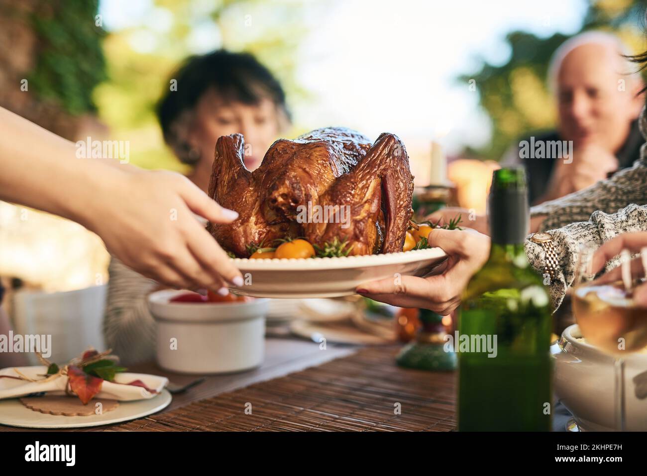 Thanksgiving, truthahn und Hände mit der Familie essen gemeinsam im Freien zur Feier der Tradition. Weihnachten, Hühnchen und Party mit einem Mann und Stockfoto