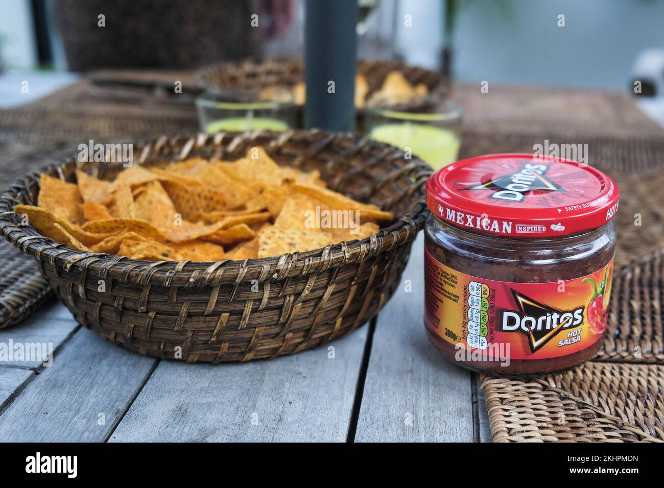 Ein Glas Doritos mexikanische Salsa und ein Korb Doritostortilla Chips auf einem Tisch. Stockfoto