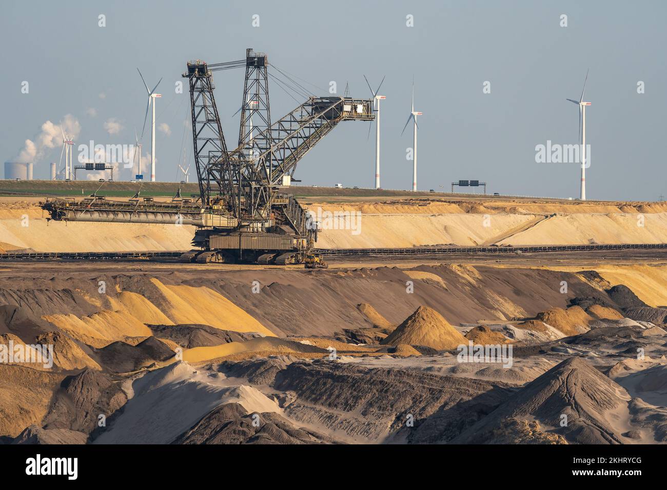 Braunkohlebergbau in Deutschland, Blick auf schwere Maschinen, Förderbänder, Aushubböden und Windturbinen im Hintergrund Stockfoto
