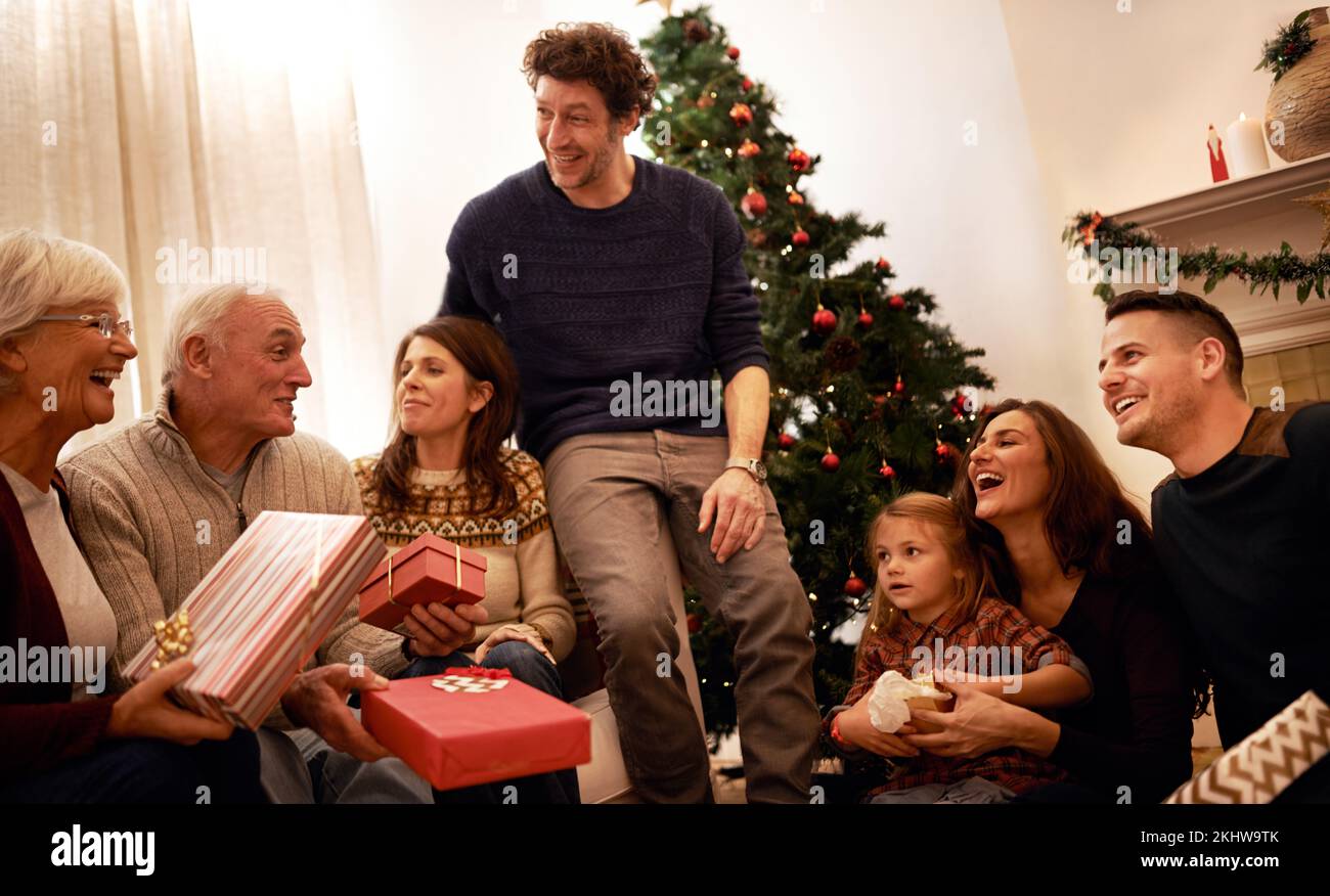 Weihnachten, Familie und Geschenk für Glück, Freude und Verbundenheit mit Lächeln, Lachen und Reden. Xmas, Großeltern und Geschwister reden, Geschenke Stockfoto