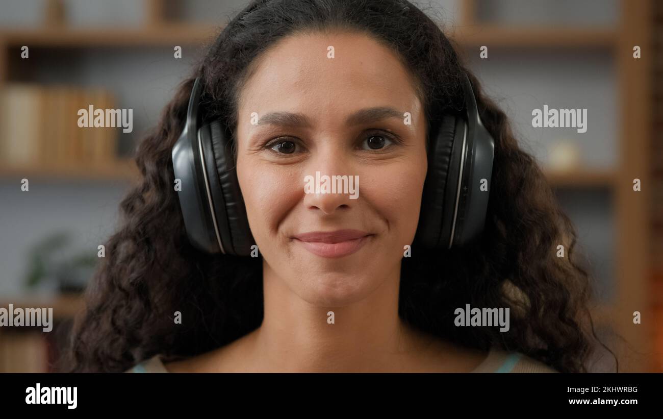 Porträt lächelnd sorglos fröhlich hispanische Latino-Kaukasierin 30s Frau, die mit Lächeln auf die Kamera schaut, genießen Sie Audio-Sound mit Kopfhörern zum Entspannen Stockfoto