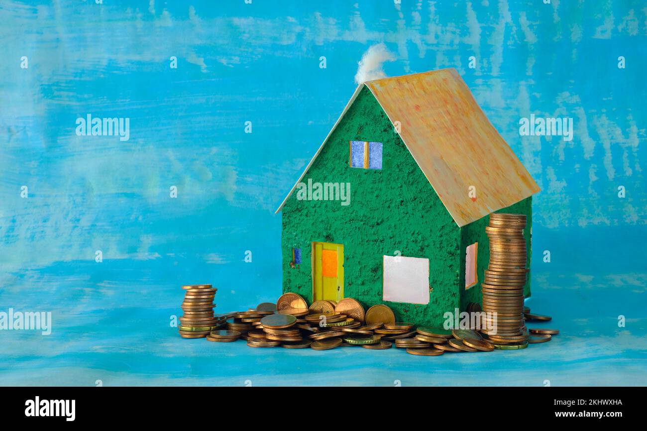 Steigende Mieten, Heizkosten und Preise für Häuser, modellieren Haus mit gestapeltem Geld, konzeptuelles, symbolisches Bild.Freier Kopierraum Stockfoto
