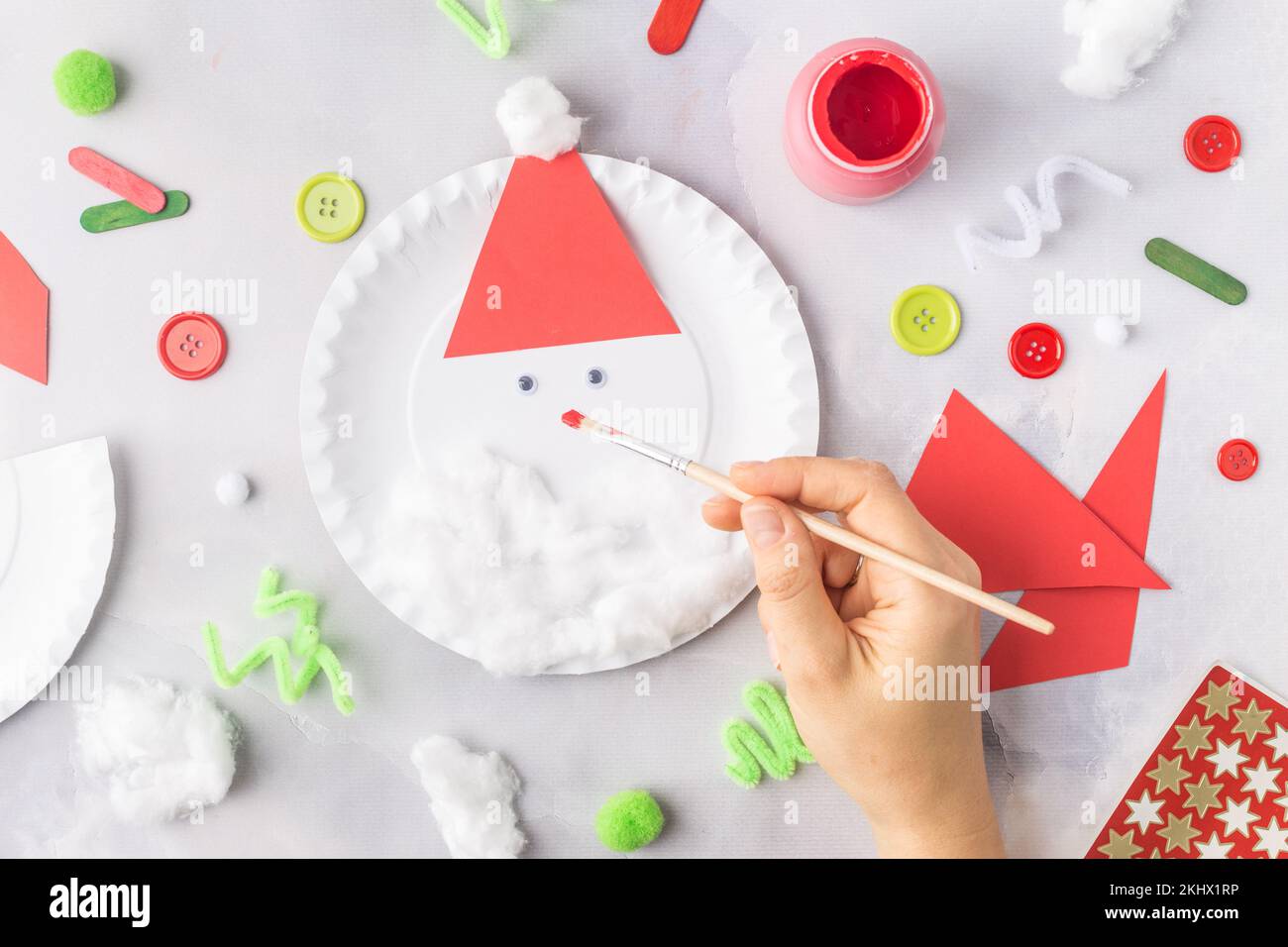 Das Kind macht eine Grußkarte Weihnachtscollage aus Papier. Mit seinen eigenen Händen gemacht. Kinderkunstprojekte für Kinder. Handwerk für Kinder. Draufsicht Stockfoto