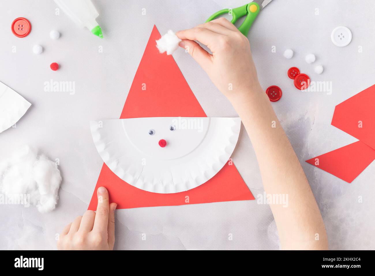 Das Kind macht eine Grußkarte Weihnachtscollage aus Papier. Mit seinen eigenen Händen gemacht. Kinderkunstprojekte für Kinder. Handwerk für Kinder. Draufsicht Stockfoto