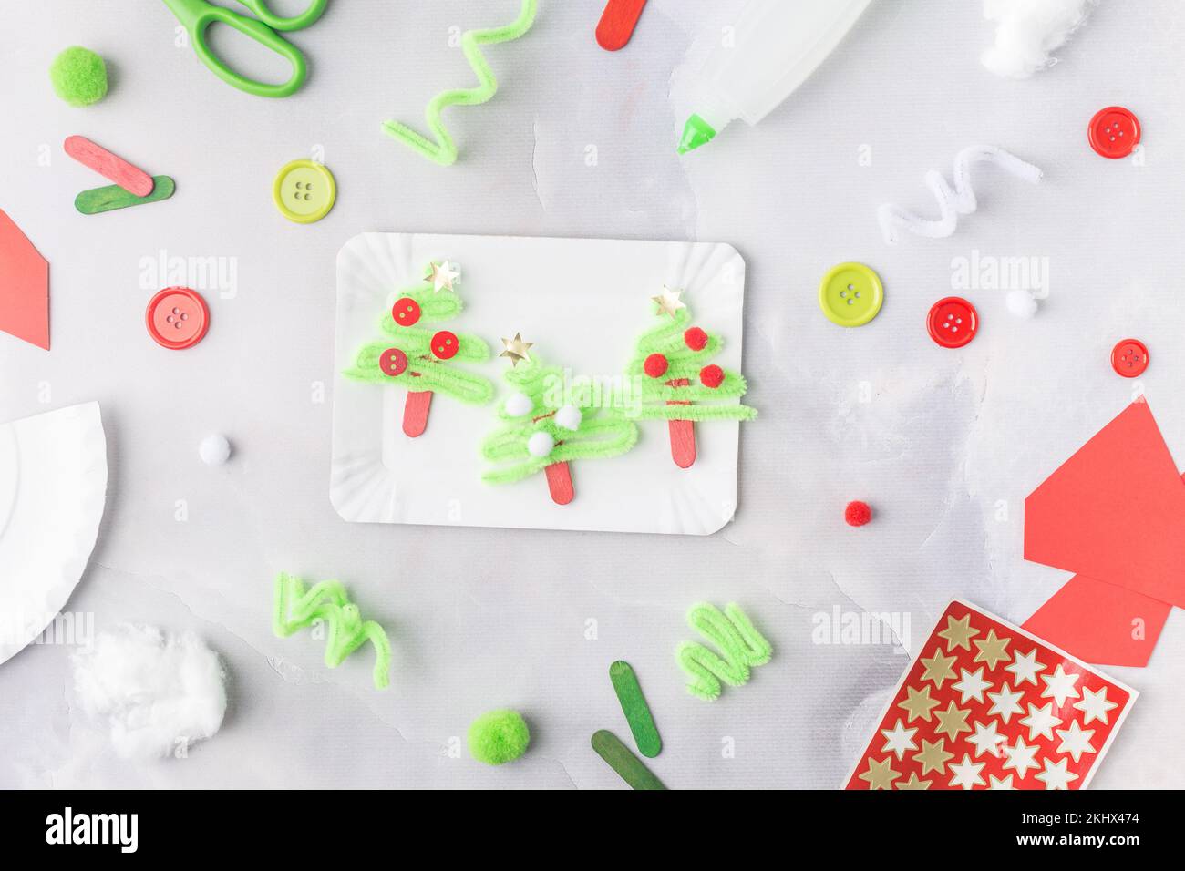 Das Kind macht eine Grußkarte Weihnachtscollage aus Papier. Mit seinen eigenen Händen gemacht. Kinderkunstprojekte für Kinder. Handwerk für Kinder. Draufsicht Stockfoto