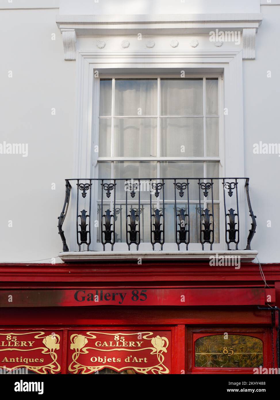 Weißes Gebäude mit Balkon über einem Geschäft an der Portabello Road in der Notting Hill Gegend von London Stockfoto